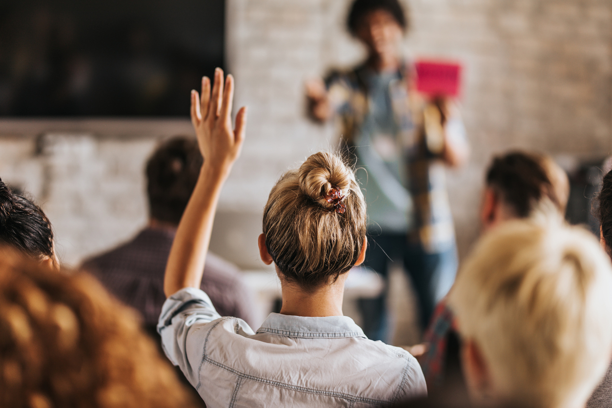 Photo of a woman raising her hand in class