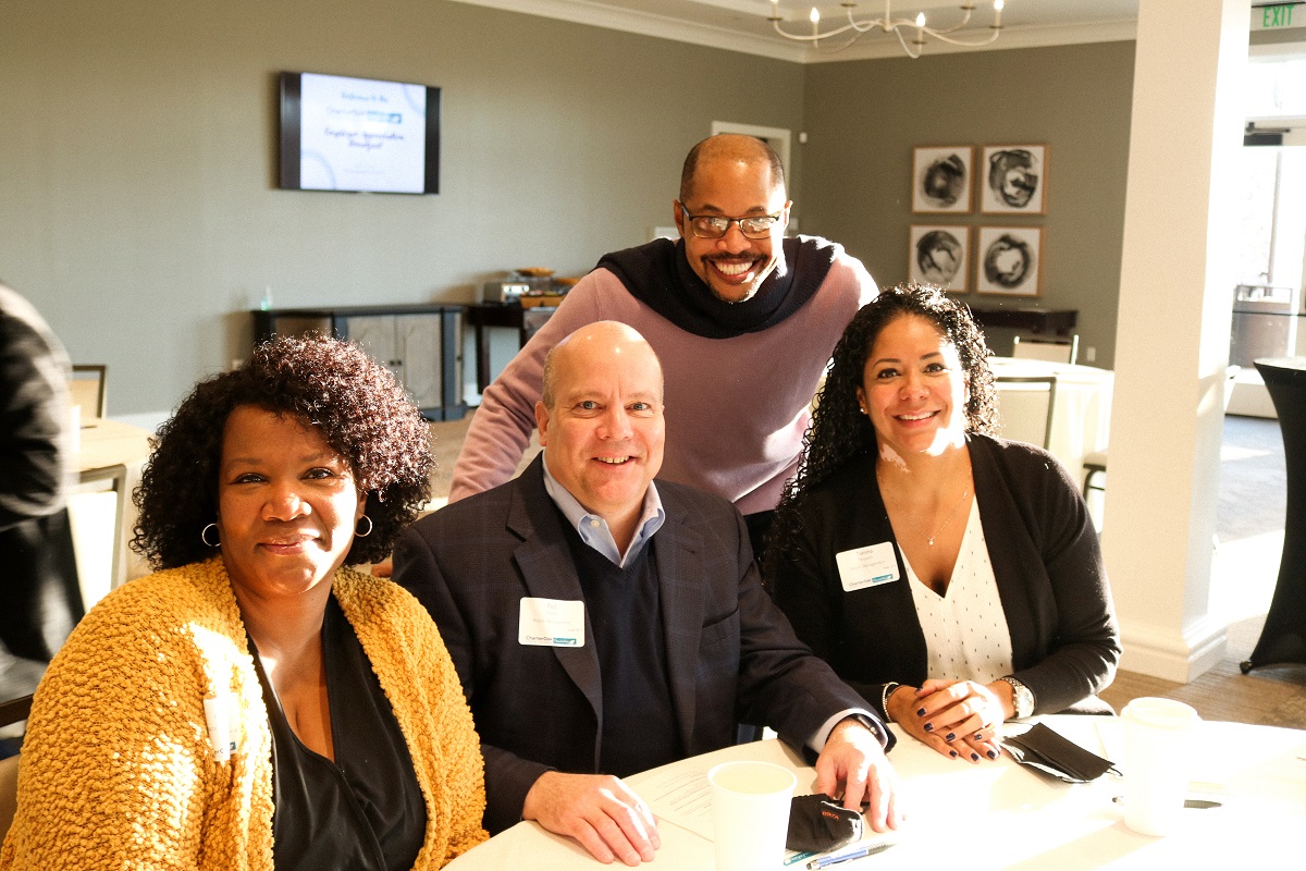 COSC Alum Mervin with three of his colleagues including his boss