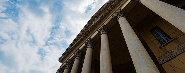 Facade of courthouse with blue sky and some clouds in the background