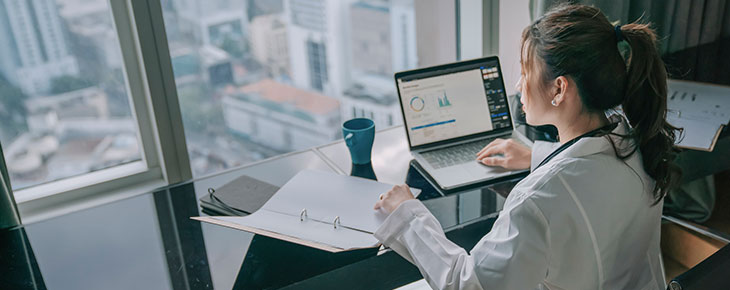 Woman on laptop in an office processing health documentation