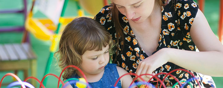 Woman and child playing in pre-school