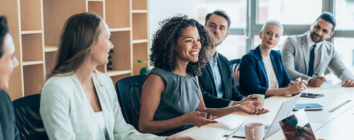 Multiethnic group of businesspeople sitting together and having a meeting in the office.