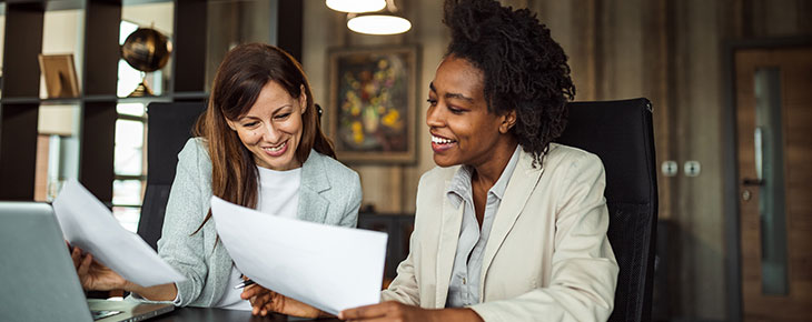 Two professional women reviewing documents