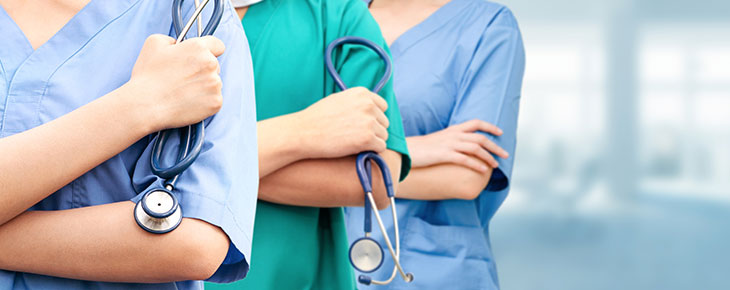 Nurses standing together with a stehoscope in their hand.