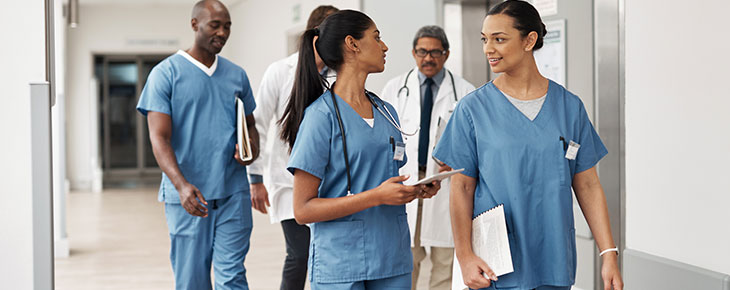 Nurses gathering and talking in a hospital hallway