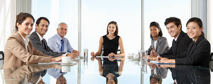People sitting at a conference room table for a meeting
