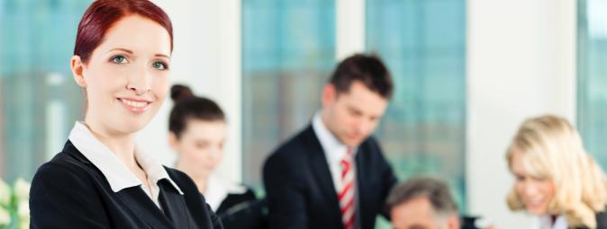 woman with arms folded in boardroom meeting