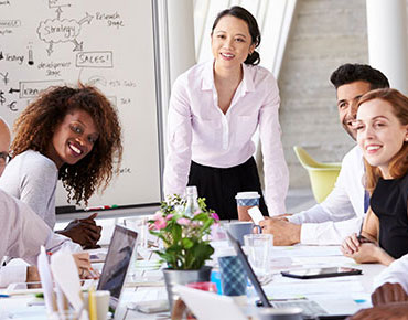 Profesiionals gathered around a whiteboard in a conference room